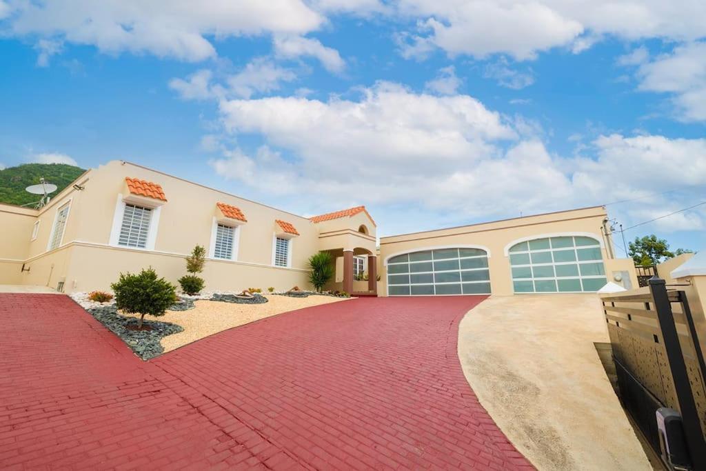 a large house with a red brick driveway at DC Luxury House in Guayama