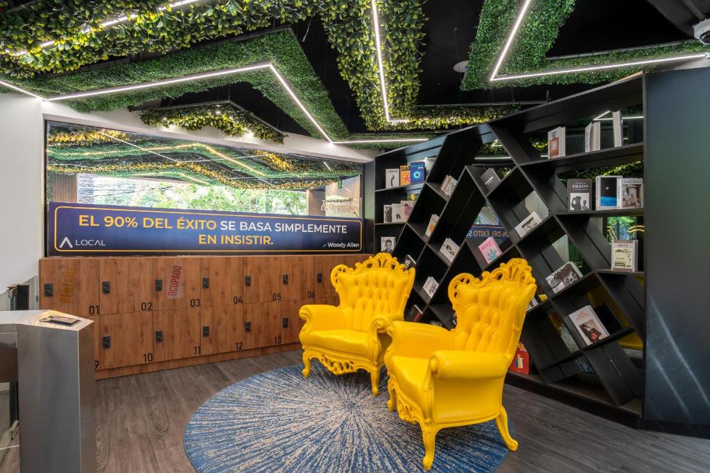 A brightly styled lounge corner with two ornate yellow chairs beside lockers and bookshelves.