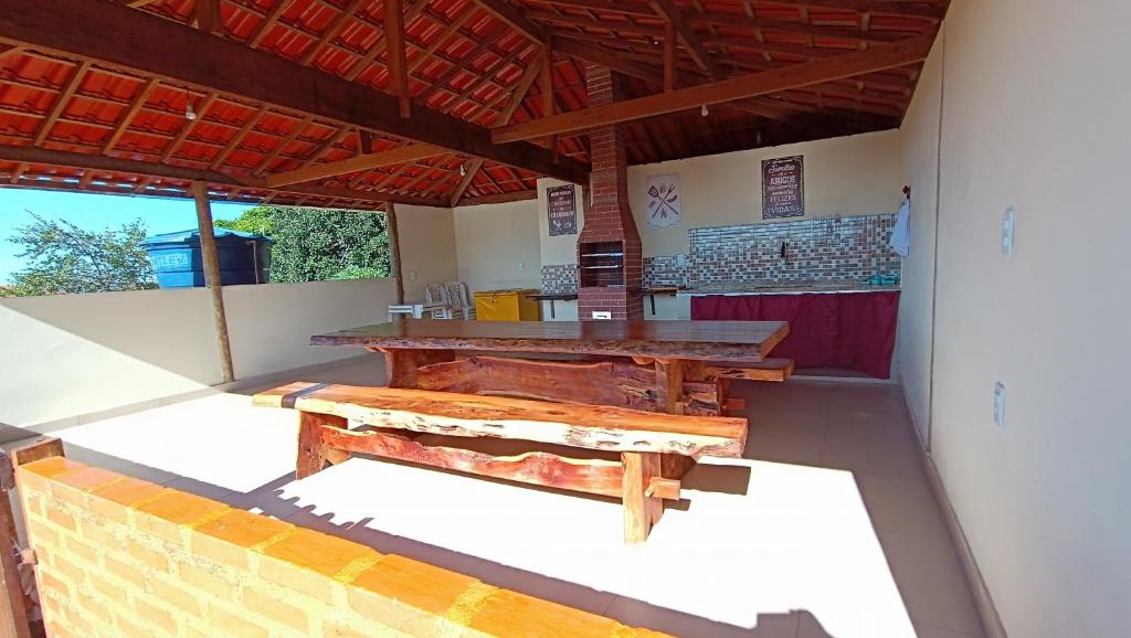 a patio with a wooden table and a bench at Casa grande, bem espaçosa, em Itambe do Mato Dentro, Cabeça de Boi in Itambé do Mato Dentro