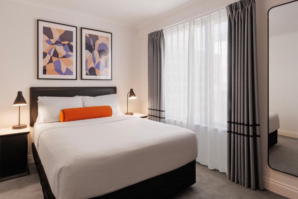 um quarto com uma cama e uma grande janela em CityLife Auckland em Auckland