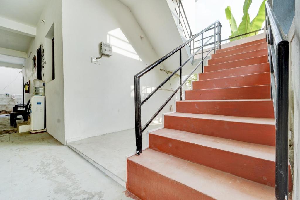 a staircase in a house with red steps at Flagship Airport Inn in Irugūr