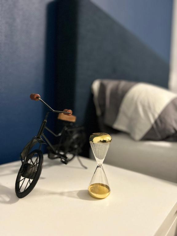 un petit vélo posé sur une table à côté d'un sablier dans l'établissement La Blue Room-Chambre Double Privée - 700m Stade de France, à Saint-Denis