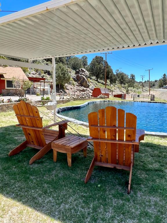 two chairs and a table under an umbrella next to a pool at Willow Springs Resort in Bridgeport
