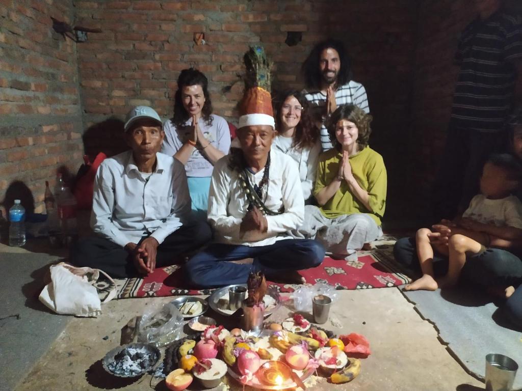 un gruppo di persone sedute sul pavimento che posano per una foto di Pemsee's Tree Town - Eco-friendly,Tree house hostel a Sauraha