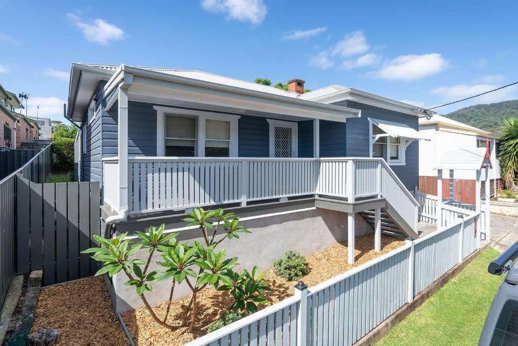 a blue house with a white fence in front of it at Blissful Beach Escape in Balgownie in Balgownie