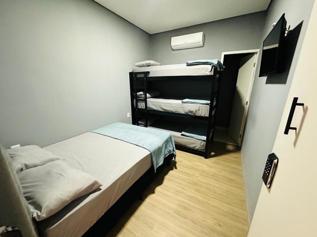 on park hotel e estacionamento traslado في جوارولوس: غرفة صغيرة مع سرير وسرير بطابقين