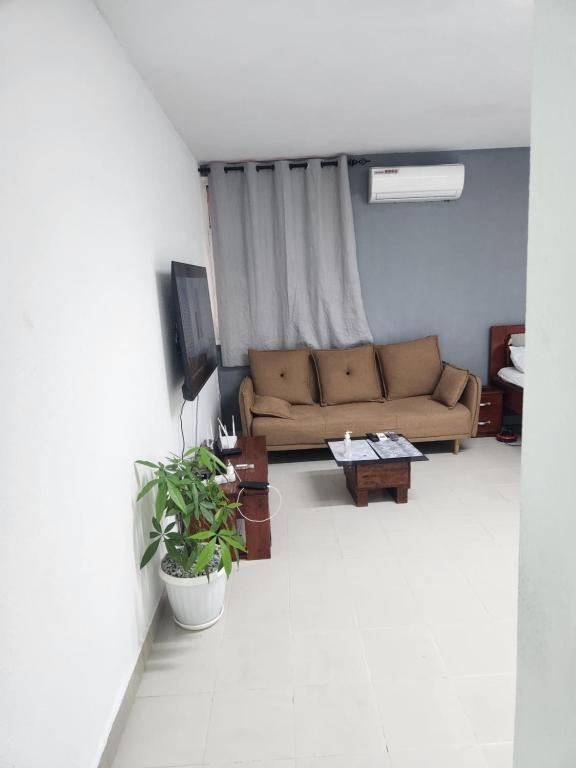 ein Wohnzimmer mit Sofa und Tisch in der Unterkunft Expert Location Service in Abidjan