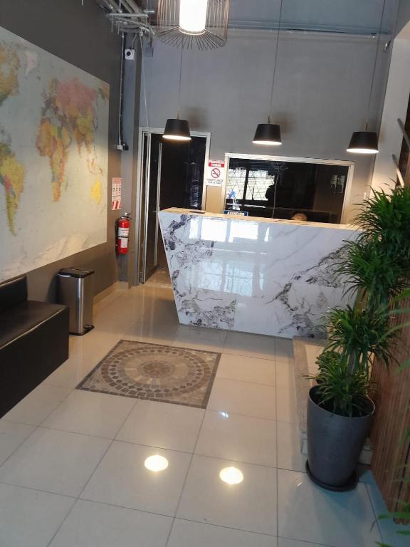 a lobby with a marble counter and a map at Hotel Singapur in San José