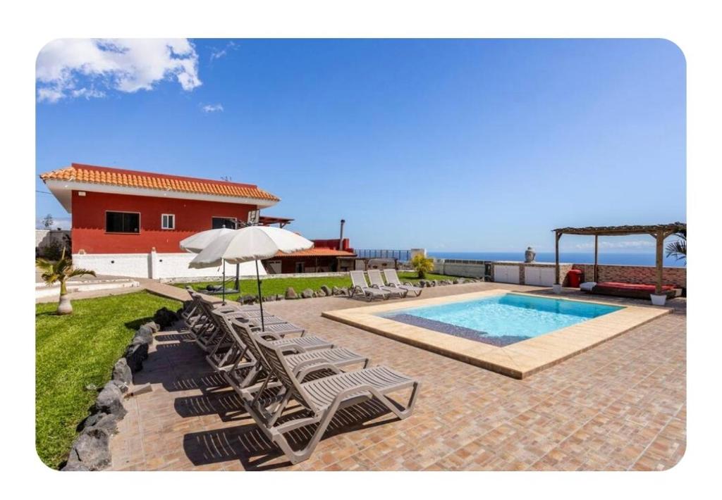 a group of lounge chairs and a swimming pool at Villa Carmen Julia 1 in Arafo