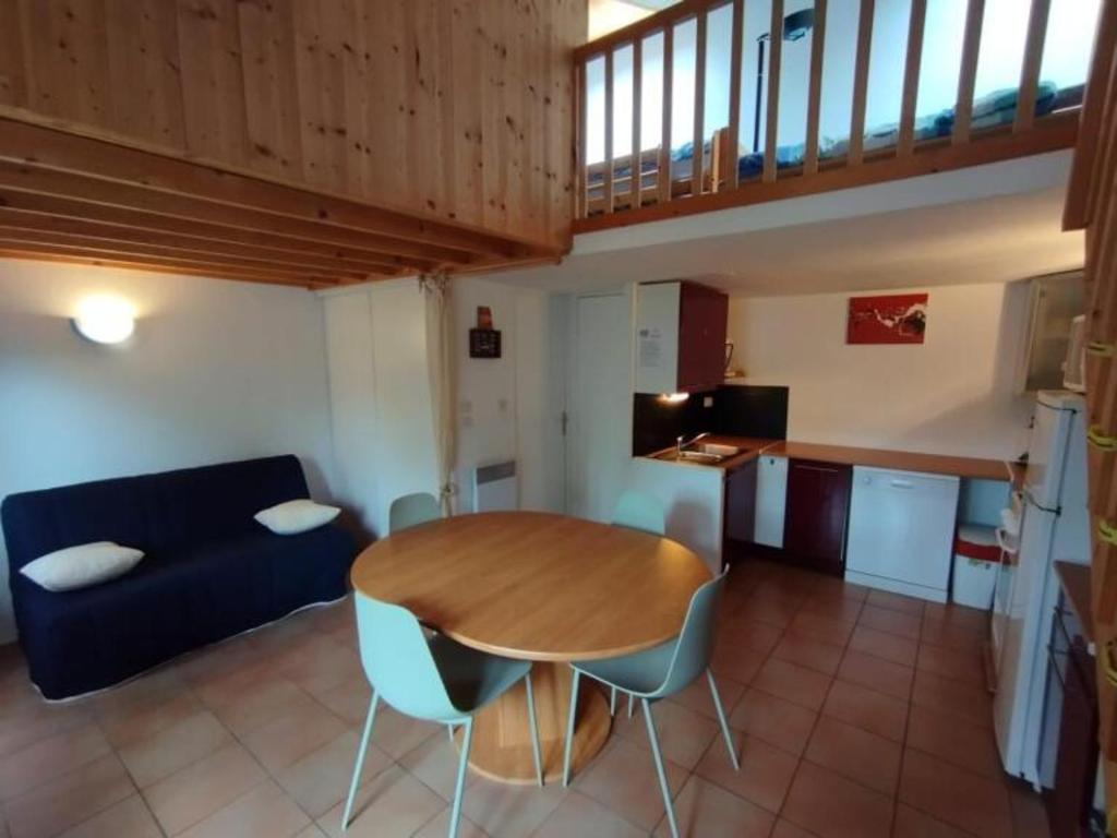 een woonkamer met een houten tafel en een blauwe bank bij Maison La Tranche-sur-Mer, 1 pièce, 4 personnes - FR-1-22-194 in La Tranche-sur-Mer