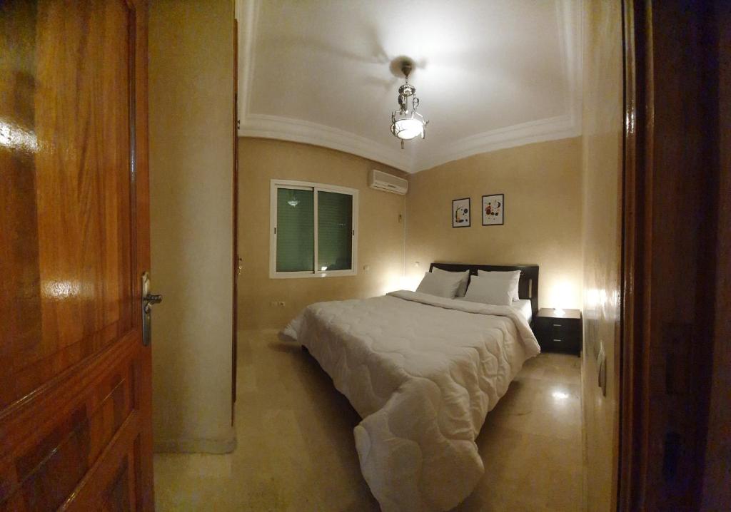 馬拉喀什的住宿－Cozy apartment in the heart of marrakech，一间卧室设有床、窗户和门