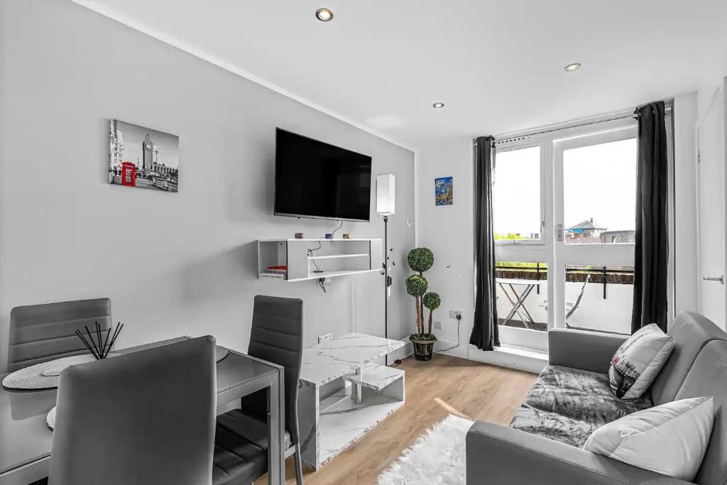 a white living room with a couch and a table at Pass the Keys Modern Flat near Tower Bridge in London