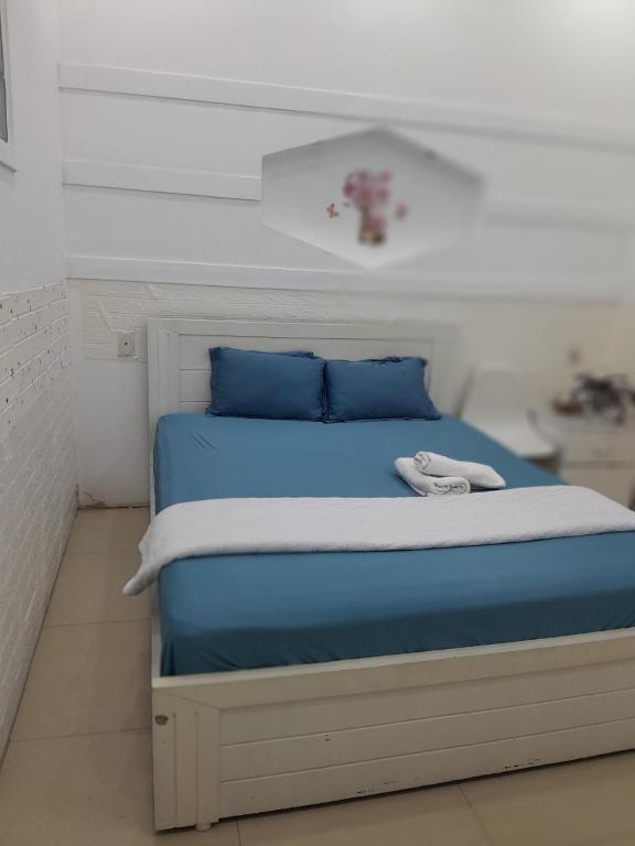 ブンタウにあるMotel Hà Myのベッド(青いシーツ、青い枕付)