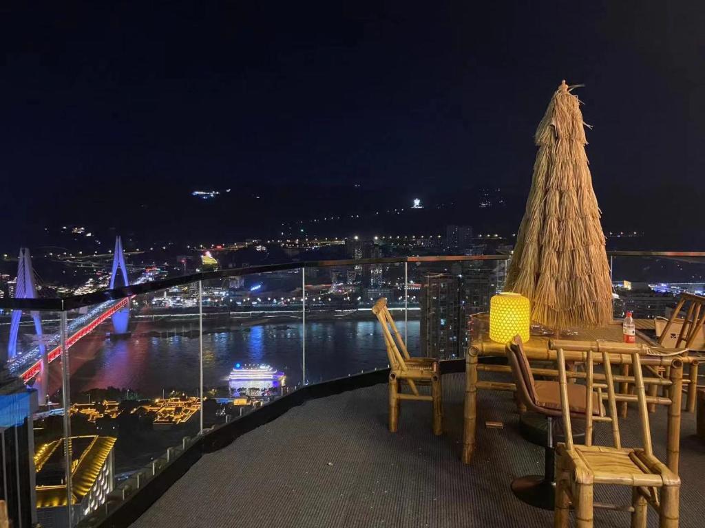 a balcony with a table and chairs and a christmas tree at Yunqi River View Terrace Hotel in Chongqing