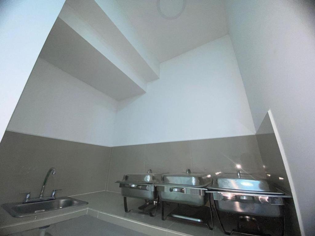 a row of sinks in a public bathroom at Hostal Tamaca Beach in Puerto de Gaira