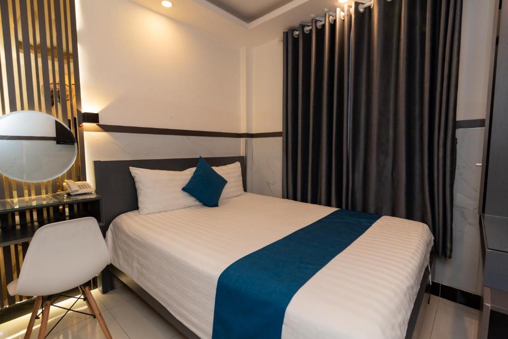 - une chambre avec un lit, une chaise et un miroir dans l'établissement Prince Hotel, à Hô-Chi-Minh-Ville
