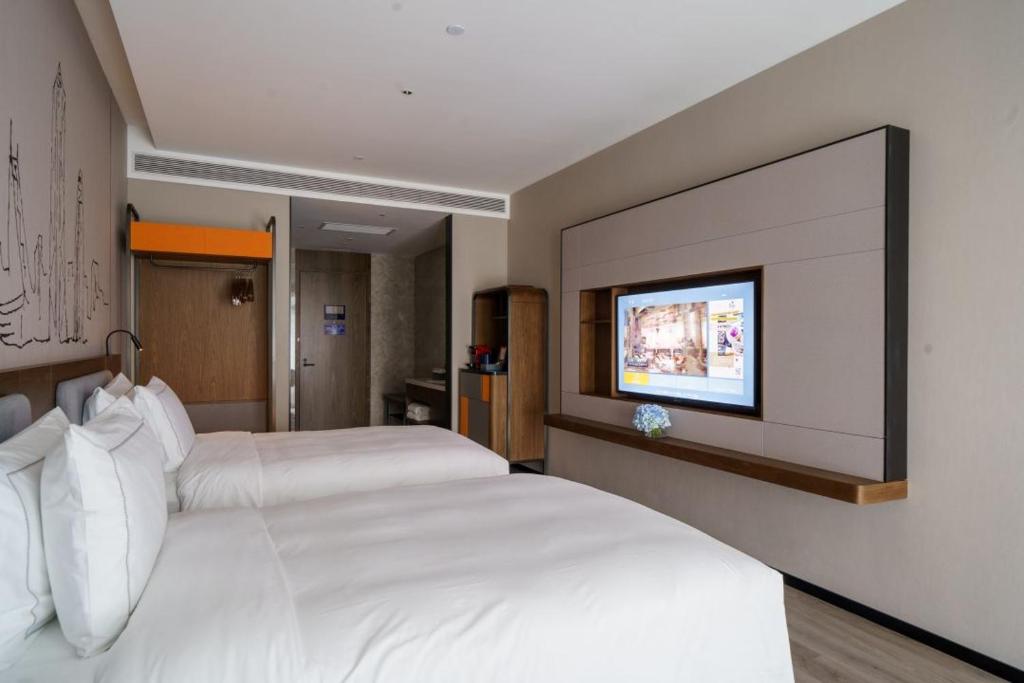 Un pat sau paturi într-o cameră la UrCove by HYATT Futian CBD-毗邻福田站和星河COCO Park 尊享免费迷你吧