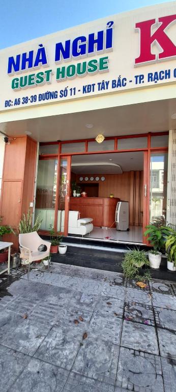 uma casa de hóspedes com cadeiras em frente a um edifício em Nhà nghỉ Kim Cương em Rạch Giá