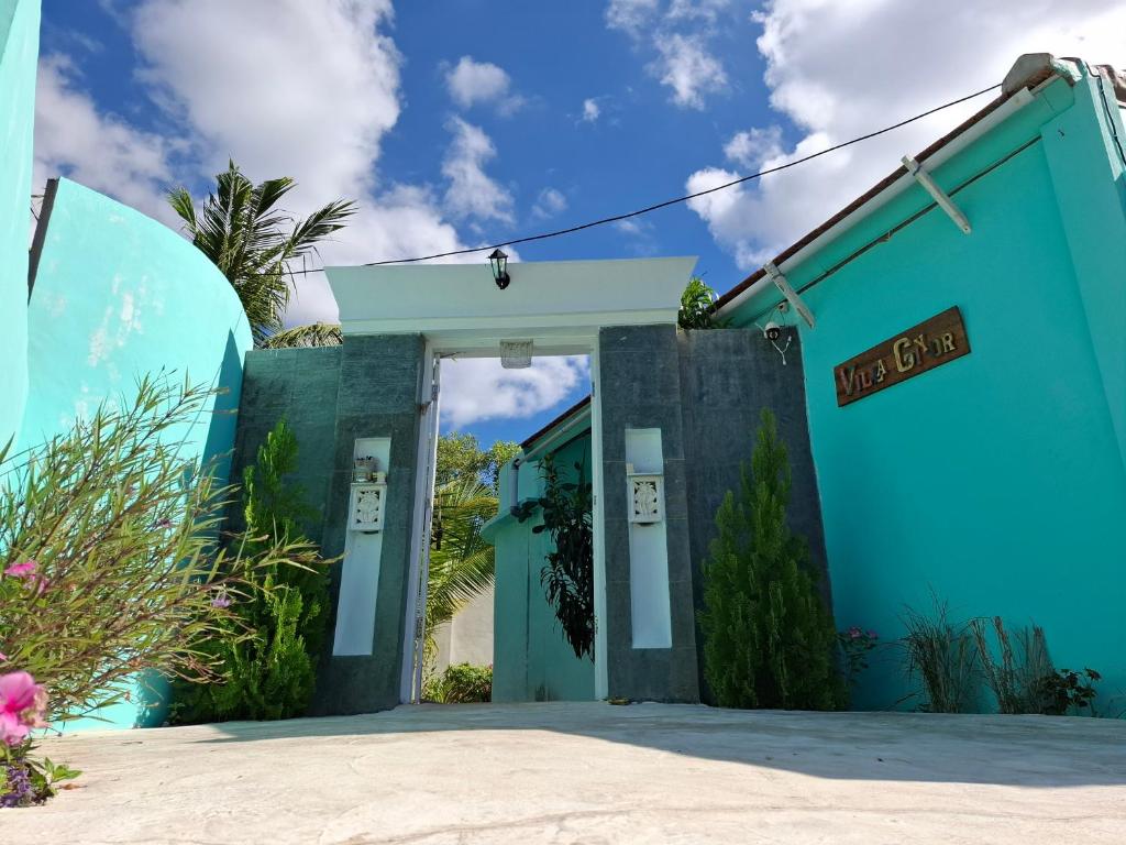 un edificio azul con un cartel que dice usagi en Villa Giyor, en Nusa Lembongan
