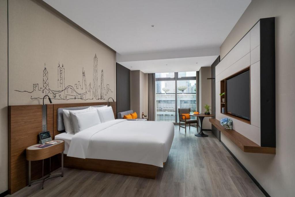 Un pat sau paturi într-o cameră la UrCove by HYATT Futian CBD-毗邻福田站和星河COCO Park 尊享免费迷你吧