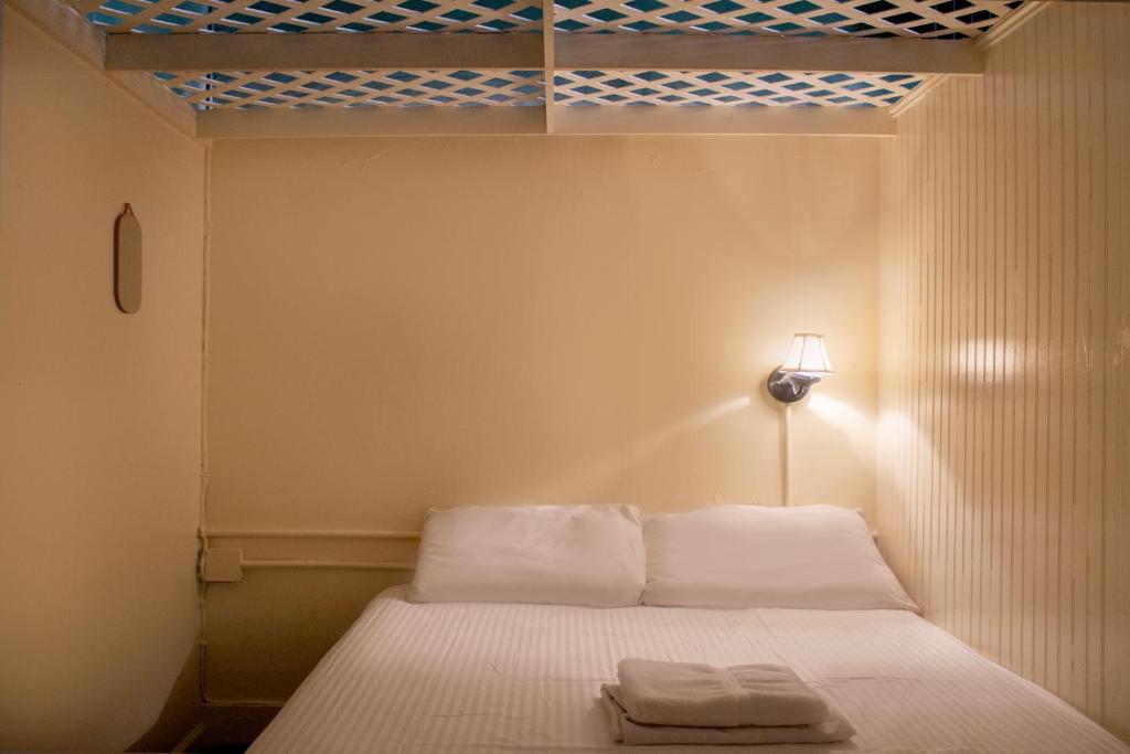 a bedroom with a bed with two towels on it at The Nolita Express Hostel in New York