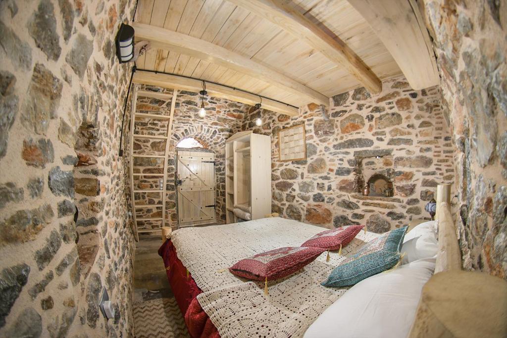 a bedroom with a bed in a stone wall at Byzantine Home in the Castle in Mesta