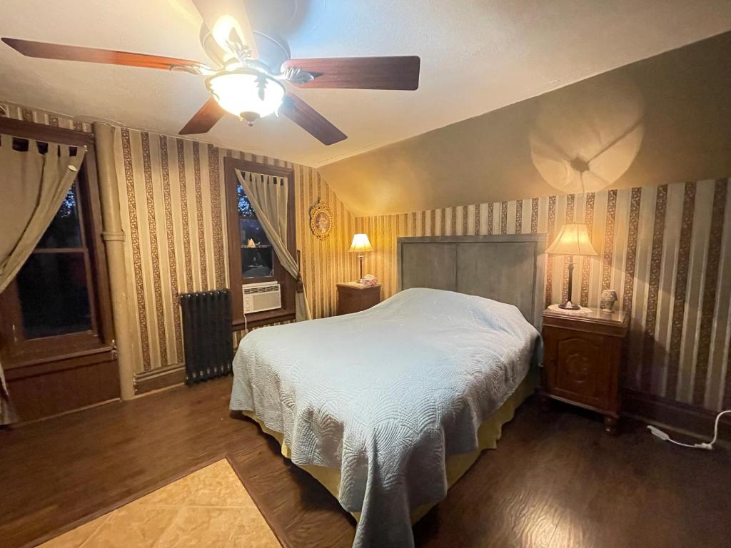 um quarto com uma cama e uma ventoinha de tecto em THE RED STAR ROOM D em Cataratas do Niágara