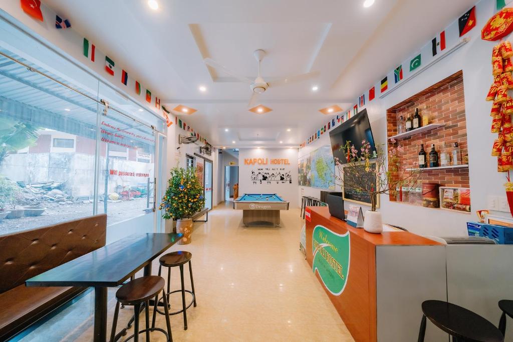 a restaurant with a counter and stools in a room at Napoli Hostel in Cat Ba