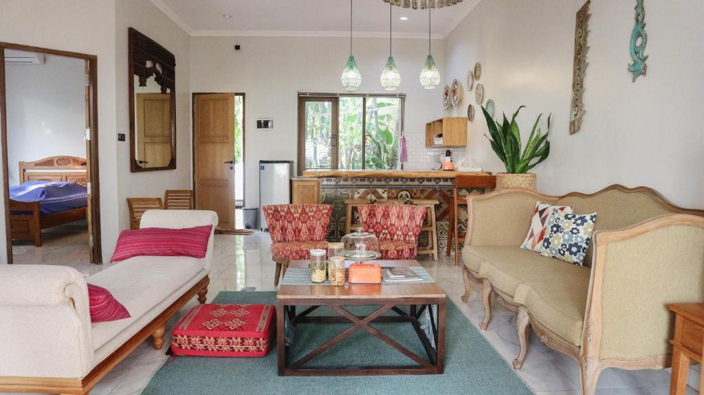 a living room with two couches and a table at Villa Gardenia Pantai Jepara in Jepara