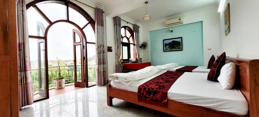 una camera con due letti in una stanza con ampie finestre di Thap Tam Royal Hotel a Ninh Binh