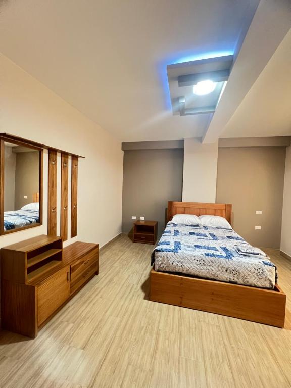 a bedroom with a bed and a mirror at Hostal Paraíso de Los Andes in Riobamba