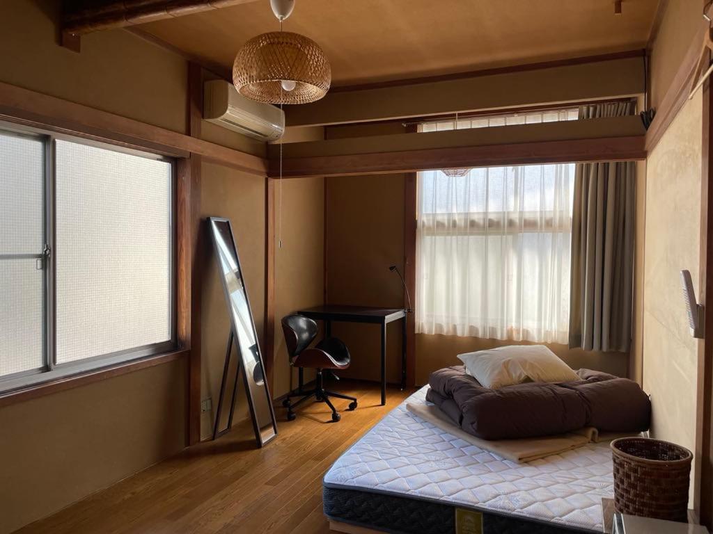 a bedroom with a bed and a desk in it at 北アルプス麓のゲストハウス林屋 204 in Omachi