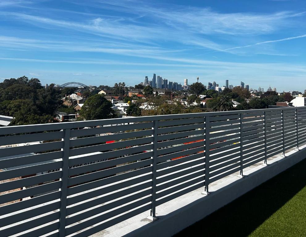 een uitzicht op de skyline van de stad vanaf een hek bij Drummoyne Apartment in Sydney