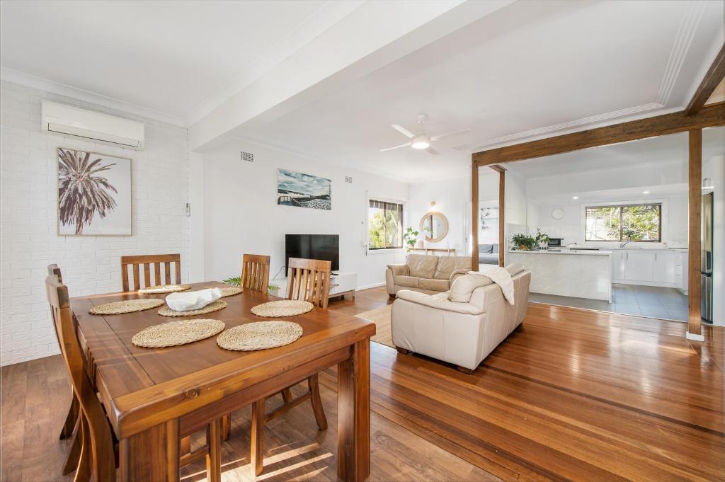 a dining room and living room with a table and chairs at Dusties 5 Pacific Street in South West Rocks