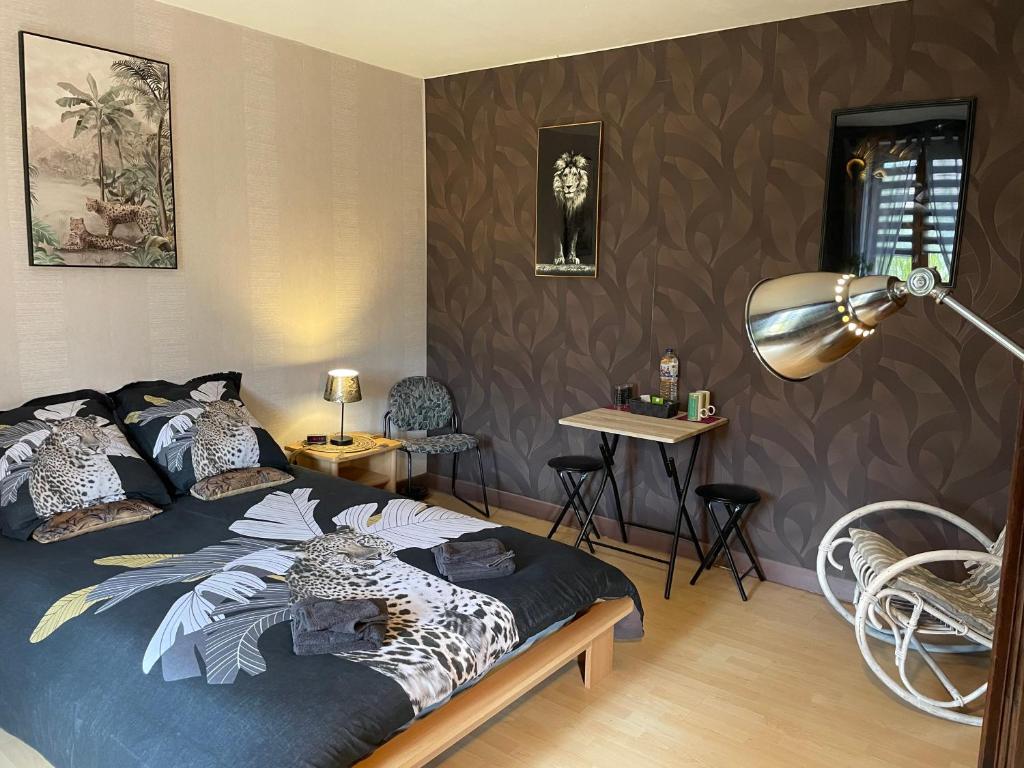 ein Schlafzimmer mit einem Bett, einer Lampe und Stühlen in der Unterkunft Bergerie Francique in Lachaussée