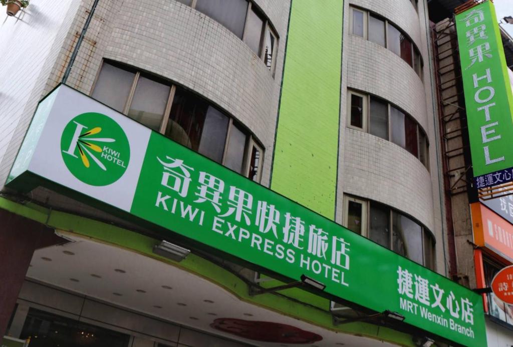 una señal frente a un edificio en Kiwi Hotel MRT Wenxin Branch (Feng Chia Branch 1), en Taichung