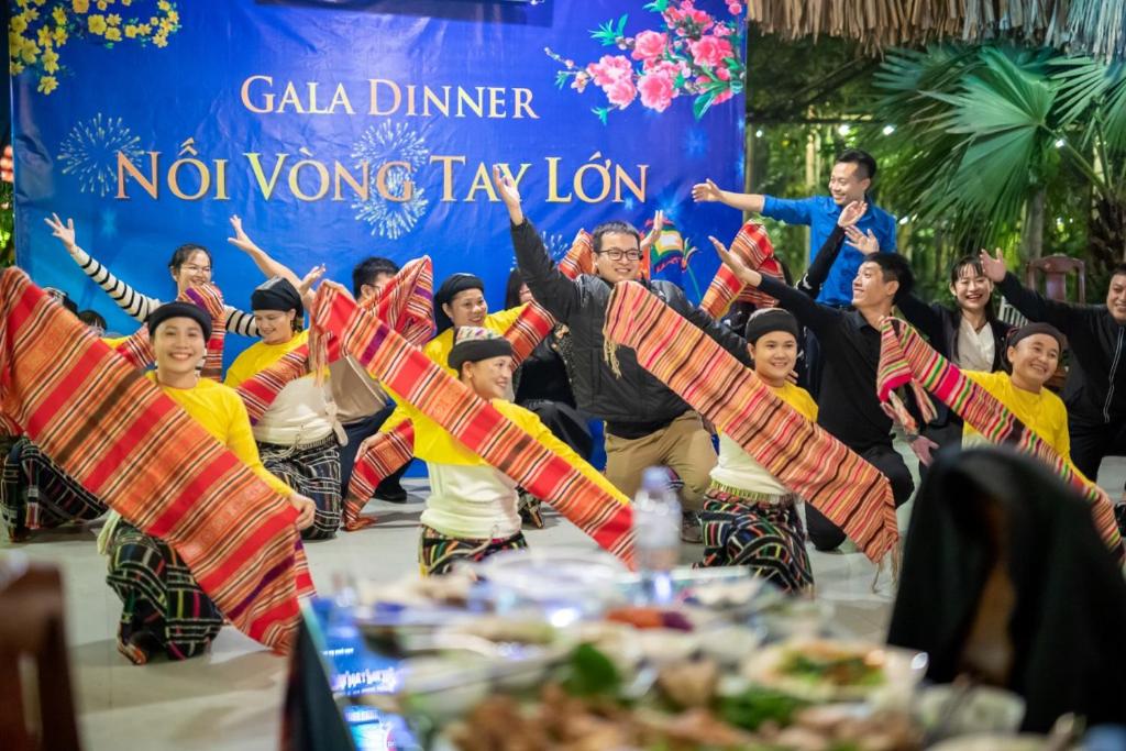 Un groupe de gens avec les mains en l'air dans l'établissement Mạ Homestay riverside, à Thanh Hóa