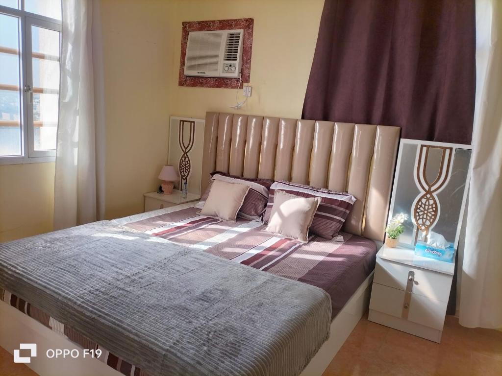 a bedroom with a large bed with purple sheets at Blossoms hills apartment in Samhān