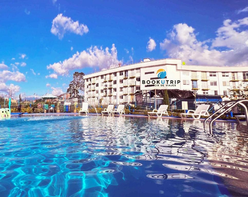 a hotel with a swimming pool in front of a building at Aparthotel 2km Parque del Café BOOKUTRIP in Montenegro