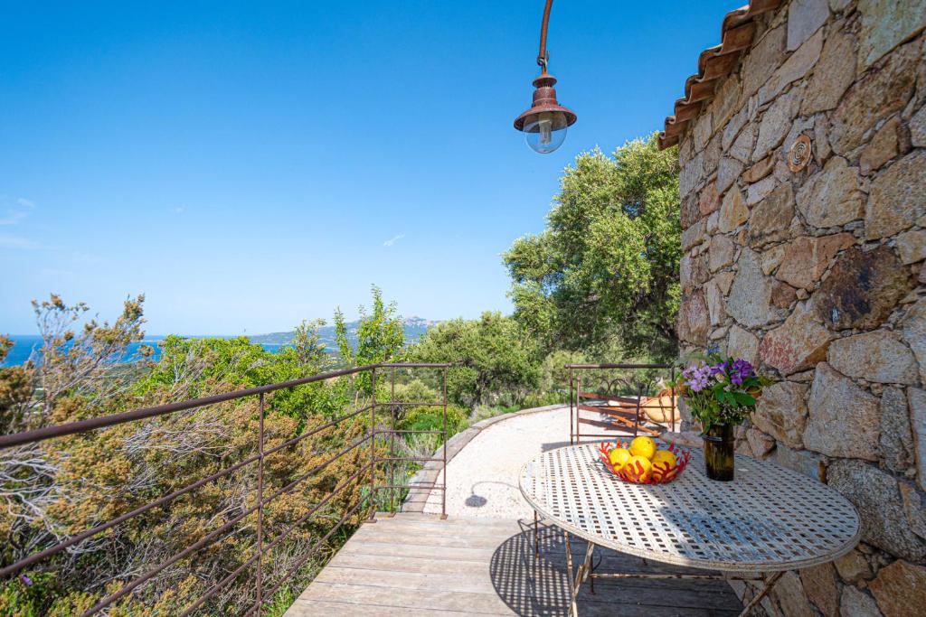 un tavolo con un cesto di frutta sul balcone di Small house in nature with splendid views 5 min from the beach and center a Calvi