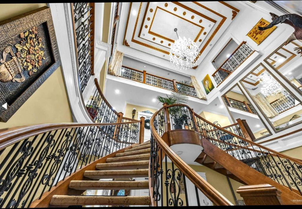サリーにあるThe Empress Palace Hotelのシャンデリアのある家の螺旋階段