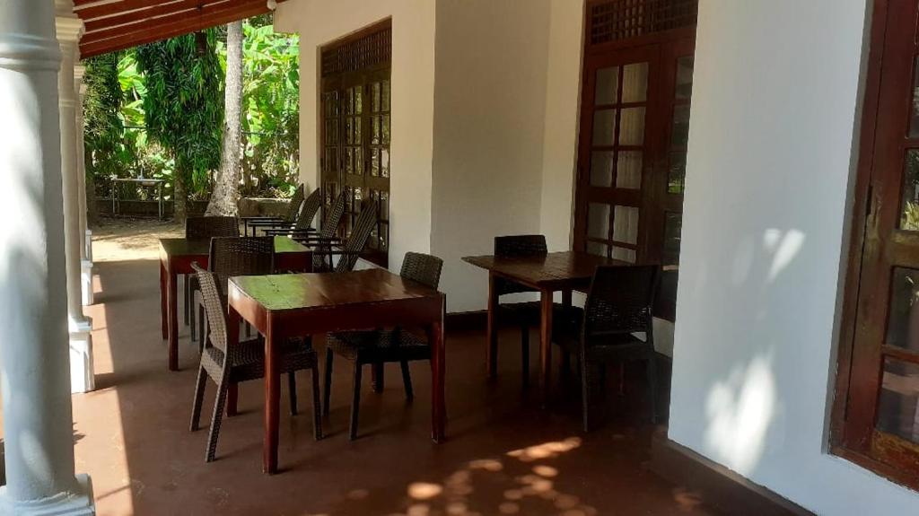 un groupe de tables et de chaises dans une pièce dans l'établissement Greeno Lanka, à Anurâdhapura