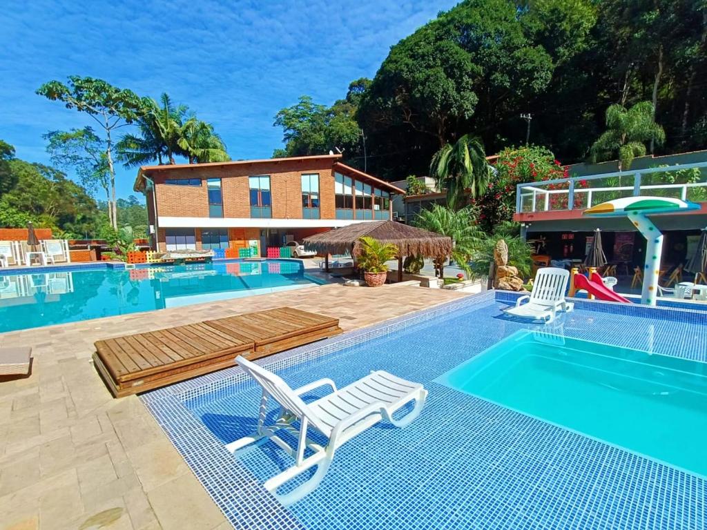 - une piscine avec 2 chaises longues et un complexe dans l'établissement EcoHotel Vale do Sol, à Embu