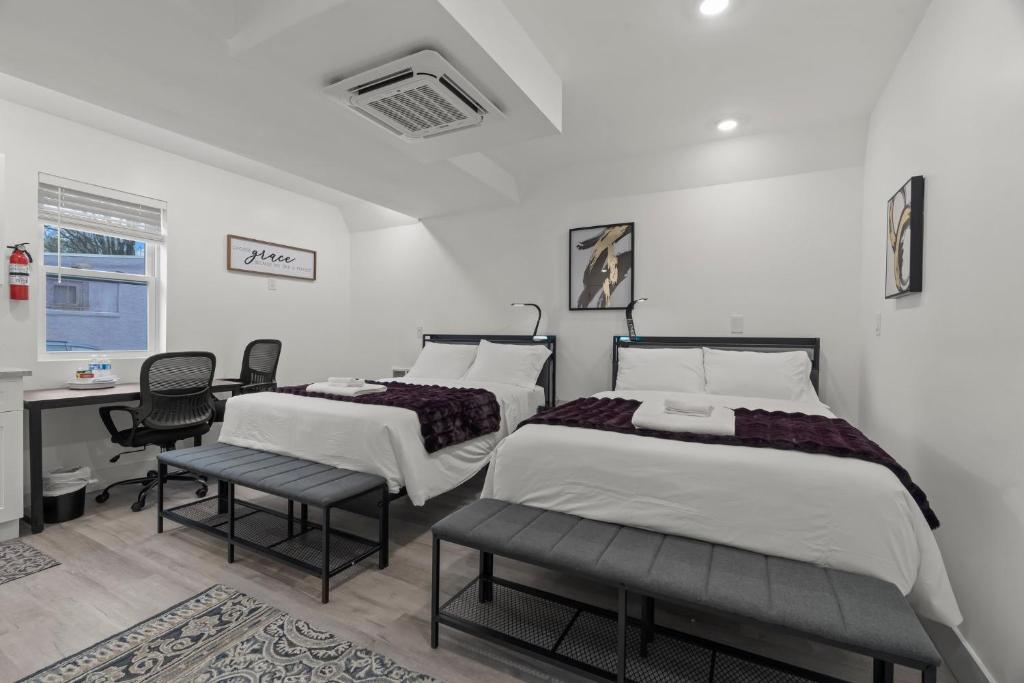 two beds in a room with a desk and chairs at New Season Royals, Airport West in Chester