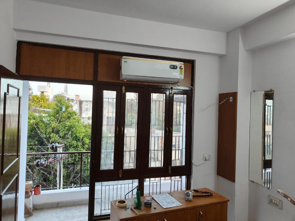 een kamer met een groot raam en een bureau bij RK homestay in Udaipur