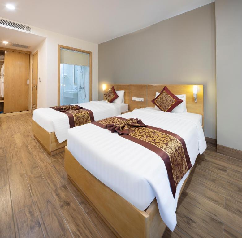 Postel nebo postele na pokoji v ubytování Gibson Hotel Nha Trang