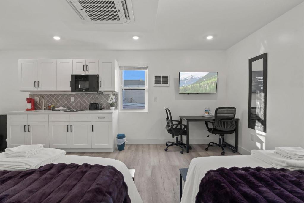 a bedroom with two beds and a table with chairs at New Season Royals, Airport West in Chester