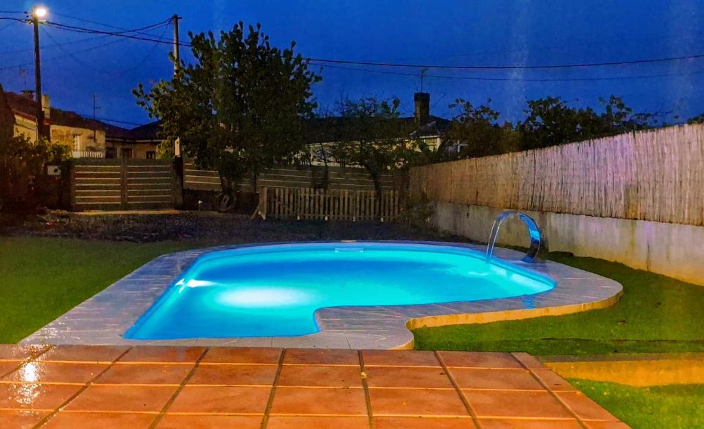 una piscina en un patio trasero por la noche en Casa Carmen con finca y piscina privada, en Cea