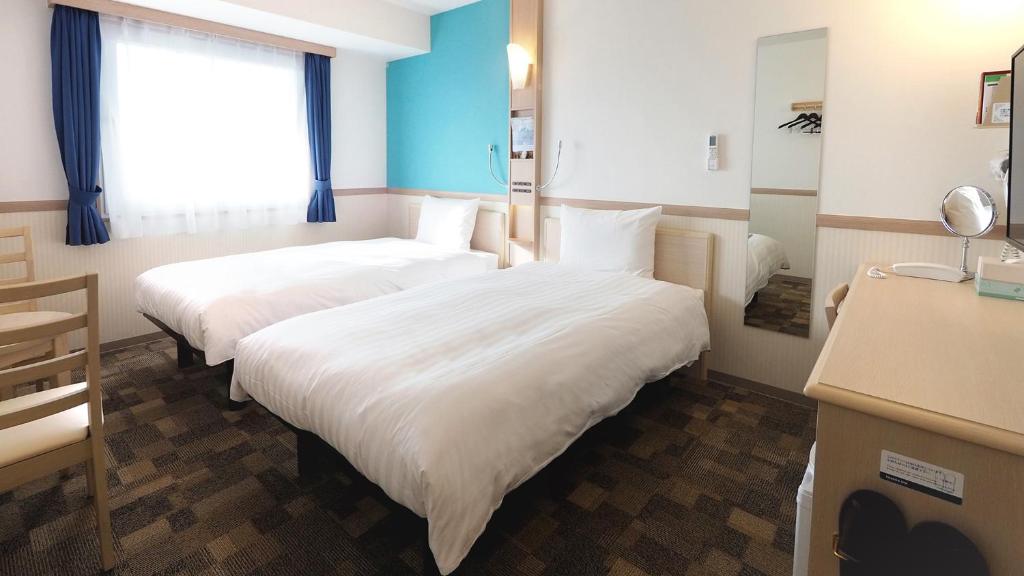 Postel nebo postele na pokoji v ubytování Toyoko Inn Iseshi Eki