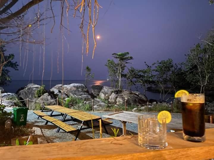 a group of picnic tables with a drink on a table at An Yen Resort in Phú Quốc